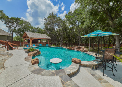 Freeform Pool Design Idea with swim up bar stools and cocktail table