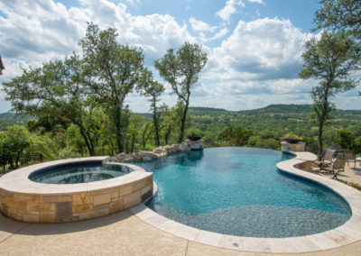 Kidney shaped Infinity Pool Design with raised spa.