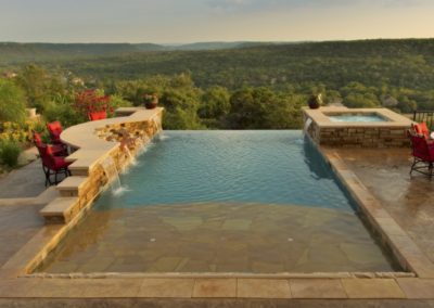 Narrow Infinity Pool with stone tanning ledge.